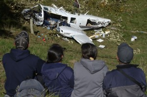 Peoplestare at  the wreckage of a Piper PA-60 Aerostar twin-engine aircraft that crashed on the eve,  on September 12, 2015 near San Pedro de los Milagros , east from Medellin, Antioquia department, Colombia  on September 12, 2015. killing two crew members and injuring another. Two people died when a plane carrying crew members from a film starring Tom Cruise crashed in Colombia, aviation authorities and Universal Pictures said. AFP PHOTO / Raul ARBOLEDA