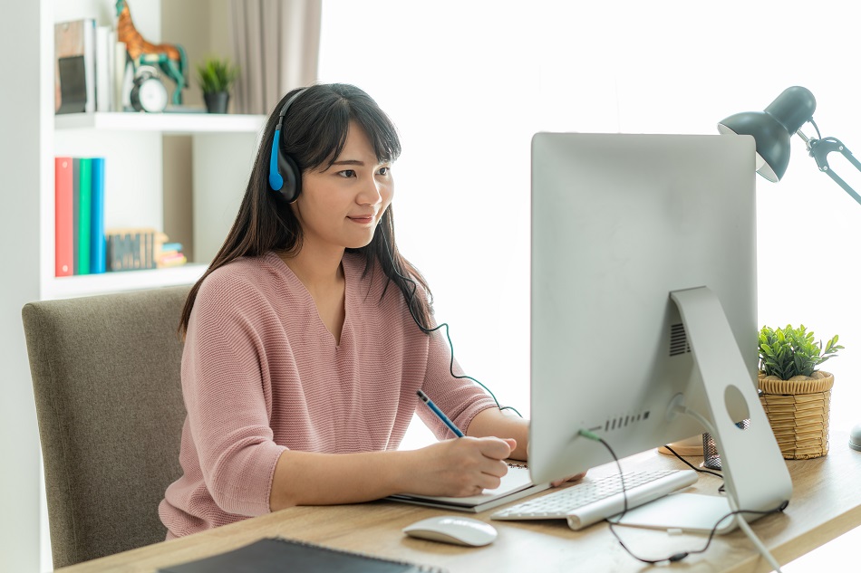 Asian woman student video conference e-learning with teacher on computer in living room at home. E-learning ,online ,education and internet social distancing protect from COVID-19 viruses.