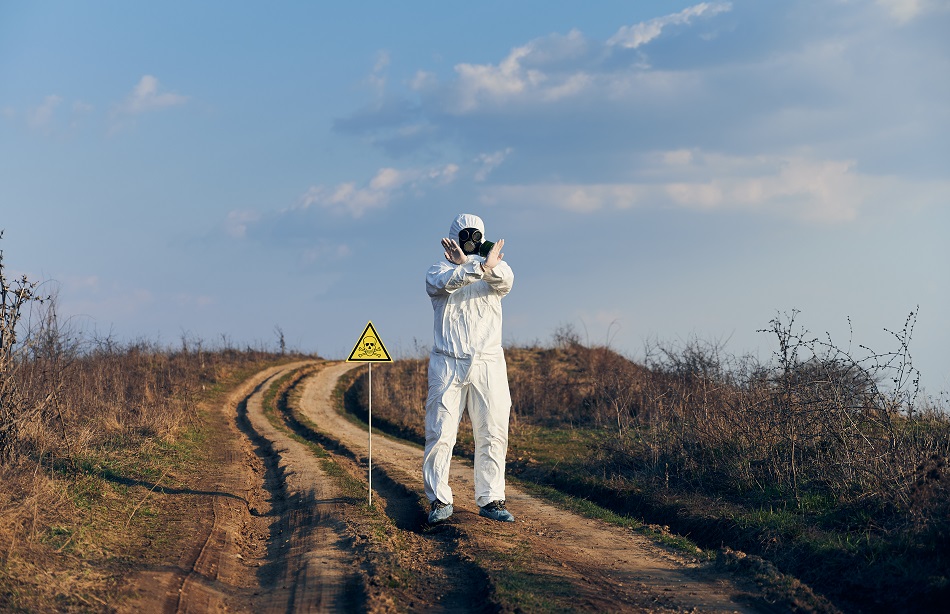 Environmentalist standing on the road with poison hazard symbol.