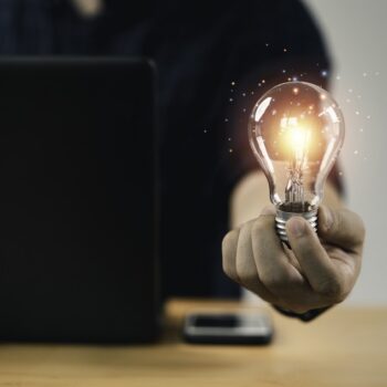 Businessman hand holding lightbulb with glowing light to creativ