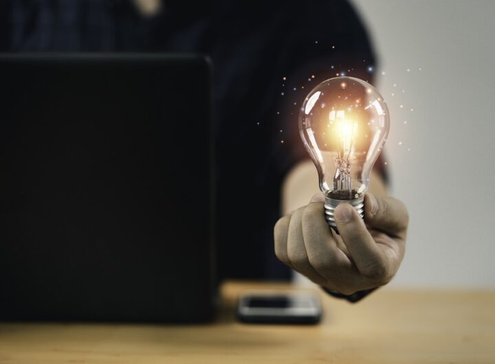 Businessman hand holding lightbulb with glowing light to creativ