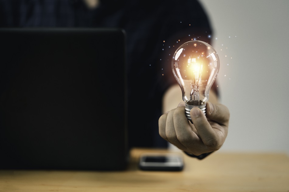 Businessman hand holding lightbulb with glowing light to creativ