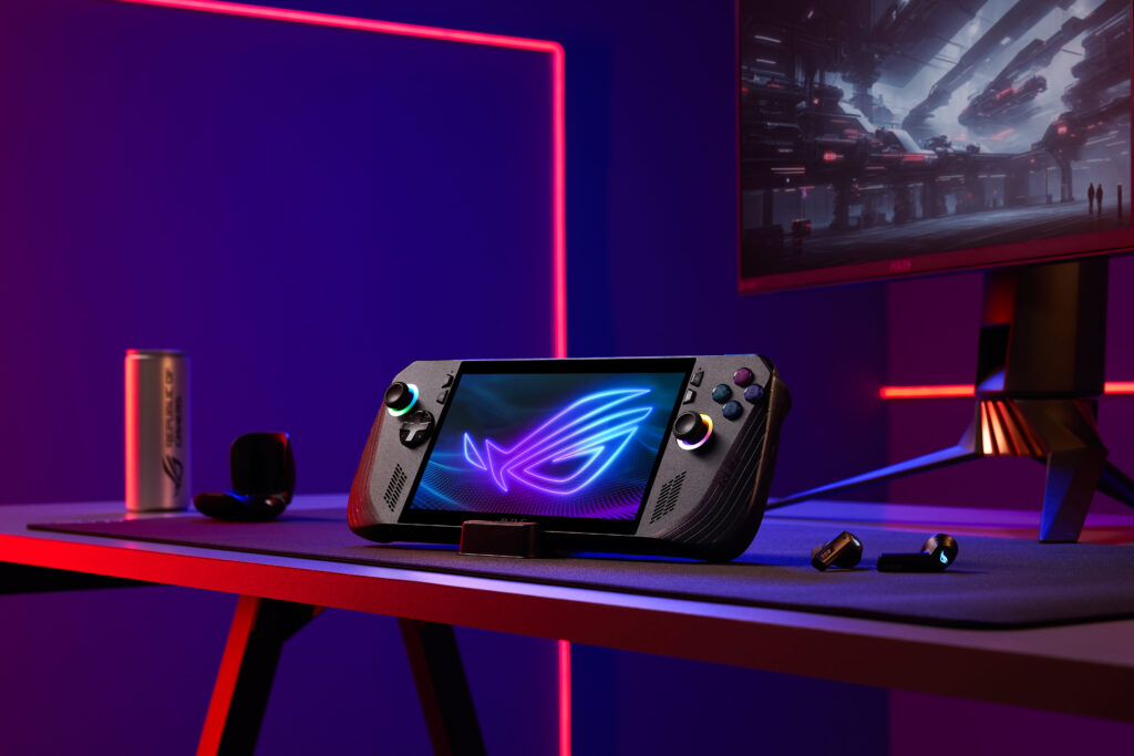 05_gaming setup featuring the ROG Ally X handheld console, positioned on a desk with vibrant LED lighting in the background