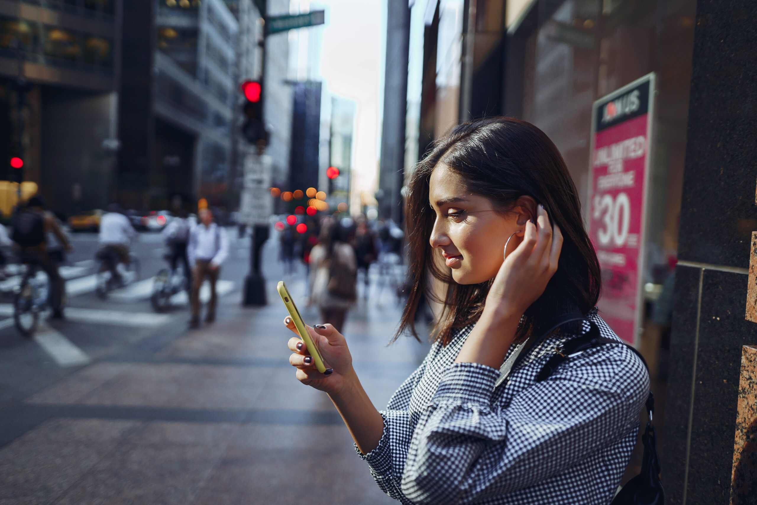 brunette girl using her cellphone to reach a friend outside